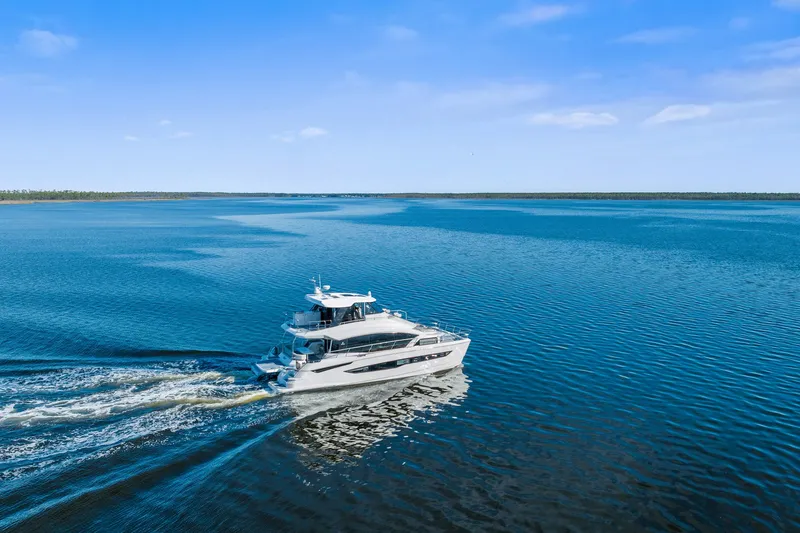 Slide: The Image of Aquila 54 Yacht cruising on open water, 2021 model, under clear blue skies. - 53