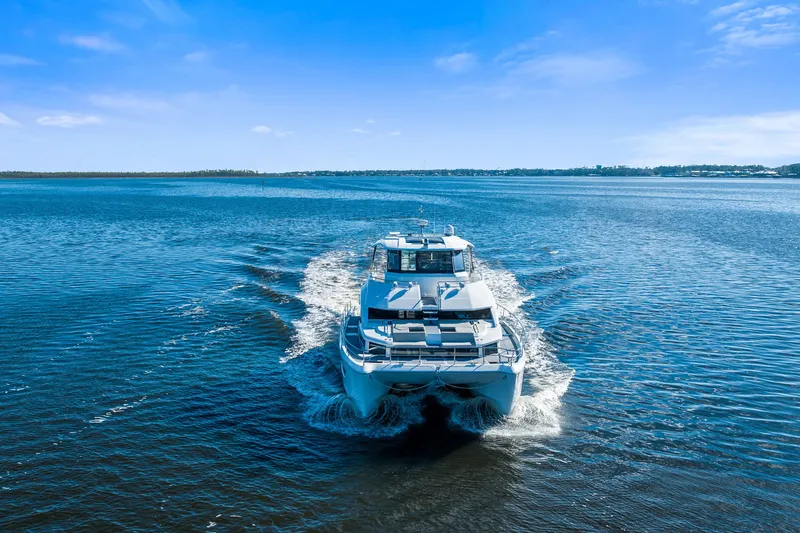 Slide: The Image of Aquila 54 Yacht cruising on open water under a clear blue sky, 2021 model. - 55