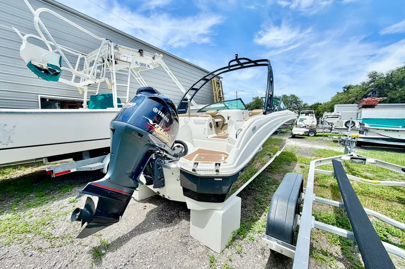 Slide: The Image of 2019 NauticStar 243 DC boat with Yamaha outboard motor, parked outdoors. - 4