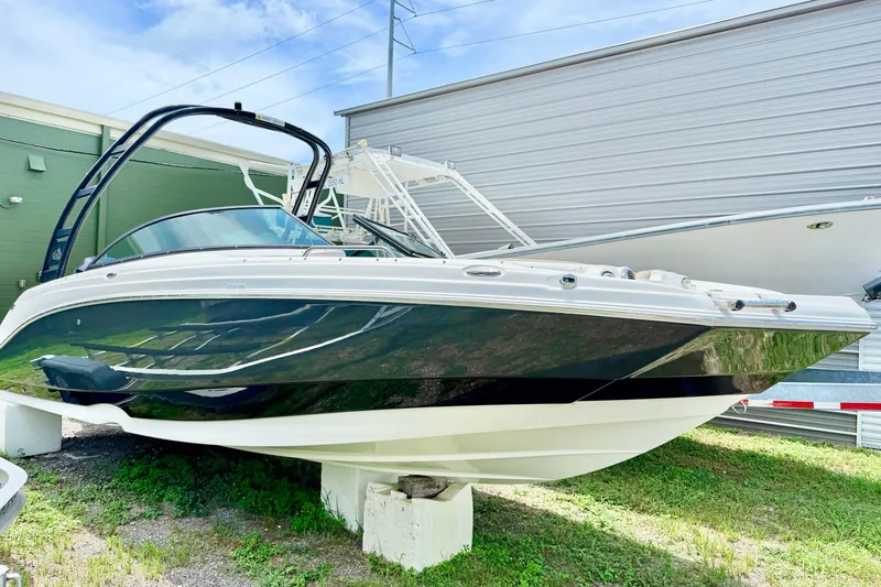 Slide: The Image of 2019 NauticStar 243 DC boat displayed outdoors on a stand. - 1