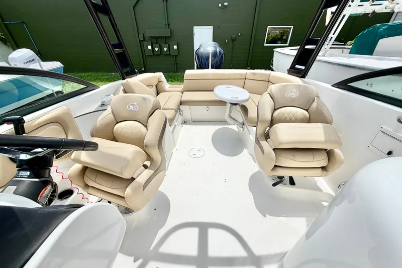 Slide: The Image of 2019 NauticStar 243 DC boat interior with beige seating and steering wheel. - 8