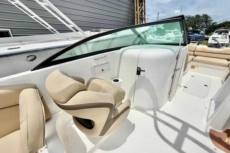 Slide: The Image of 2019 NauticStar 243 DC boat interior with beige seating and sleek design. - 9