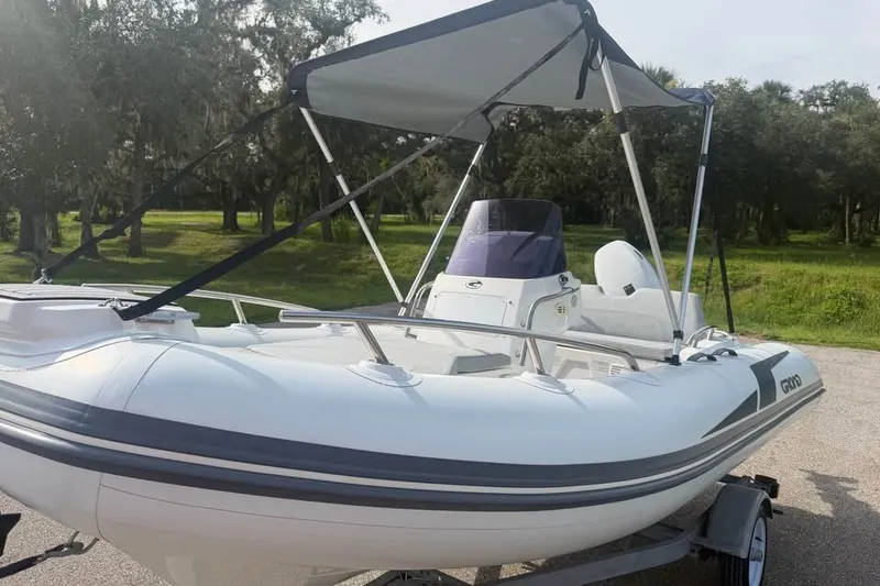 Slide: The Image of 2023 Grand G420 inflatable boat with canopy on trailer, parked outdoors. - 12