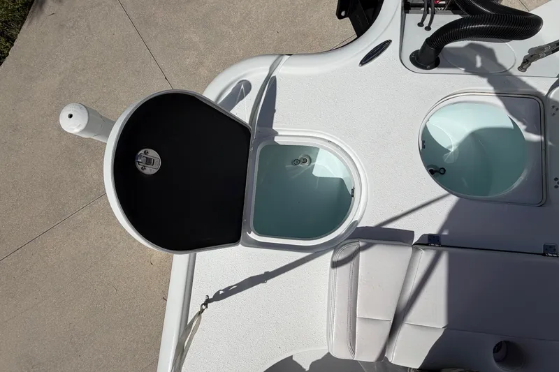Slide: The Image of 2018 Yellowfin 21 Bay boat deck with open storage compartments and seating. - 21