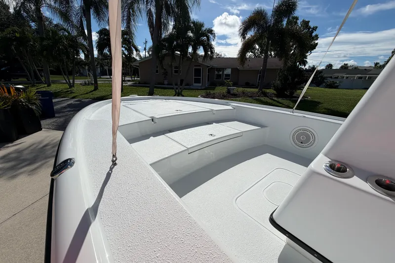 Slide: The Image of 2018 Yellowfin 21 Bay boat interior with seating, palm trees, and blue sky background. - 41