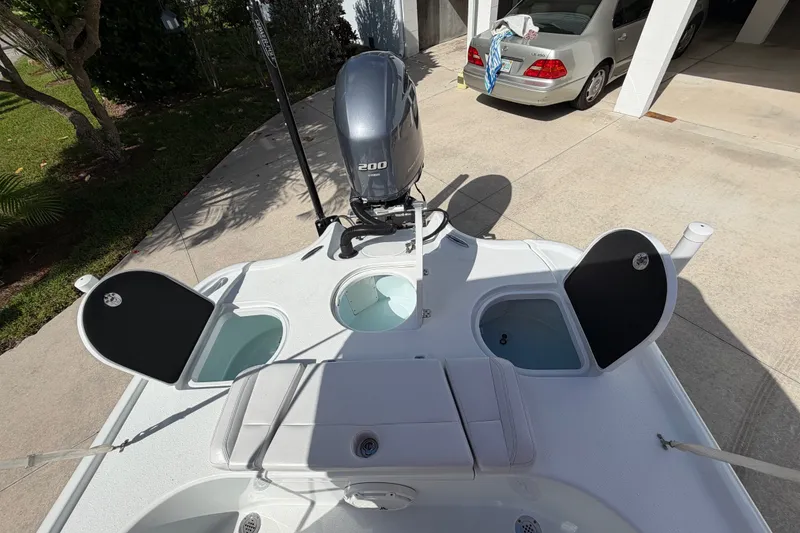 Slide: The Image of 2018 Yellowfin 21 Bay boat with open compartments and outboard motor in driveway. - 20