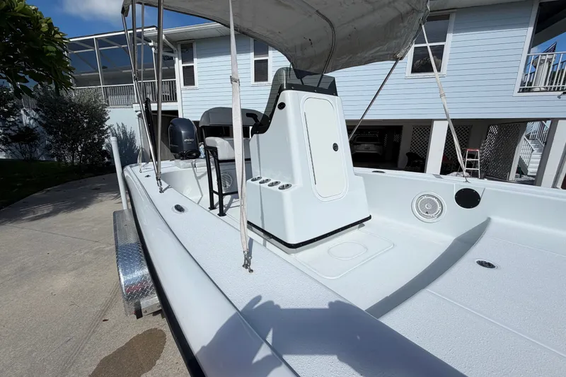 Slide: The Image of 2018 Yellowfin 21 Bay boat with canopy, parked near a house. - 33