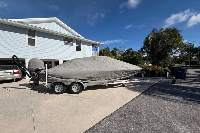 Slide: The Image of Covered 2018 Yellowfin 21 Bay boat on trailer in driveway under clear sky. - 50