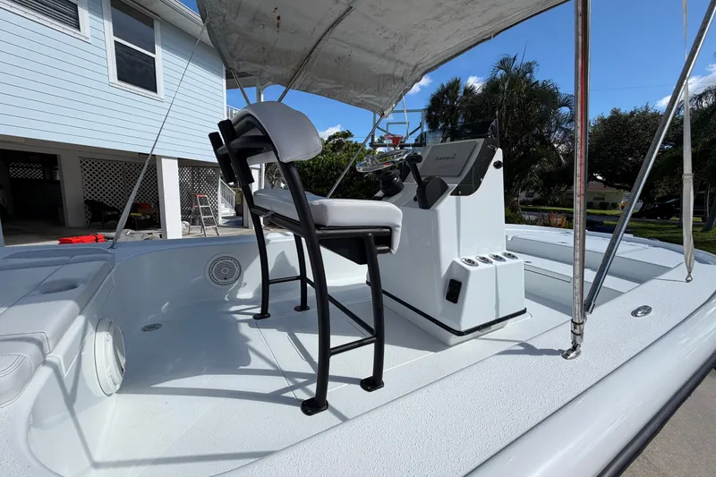 Slide: The Image of 2018 Yellowfin 21 Bay boat with console and seating, parked near a house. - 34