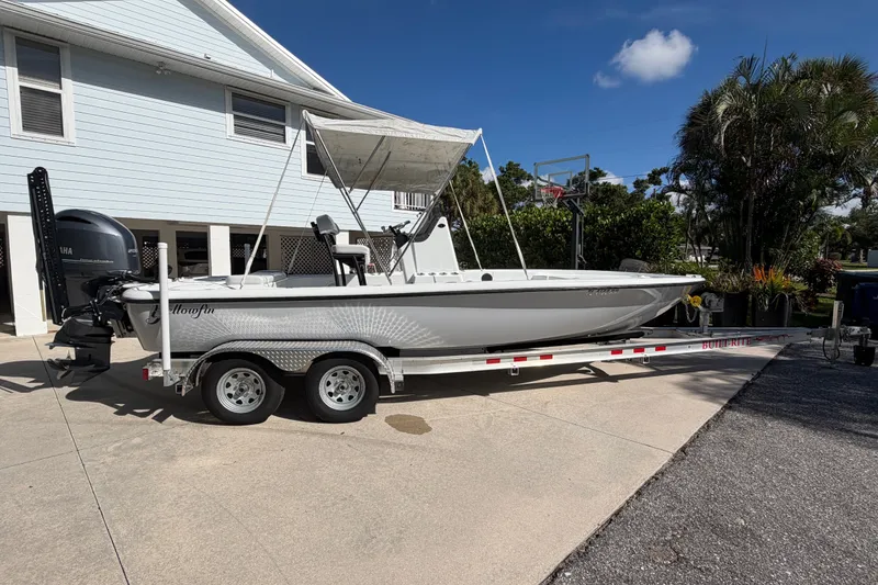 Slide: The Image of 2018 Yellowfin 21 Bay boat on trailer, parked in driveway under clear blue sky. - 8