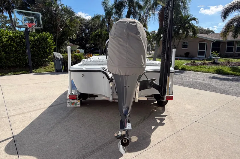 Slide: The Image of 2018 Yellowfin 21 Bay boat on trailer in sunny driveway with palm trees. - 2