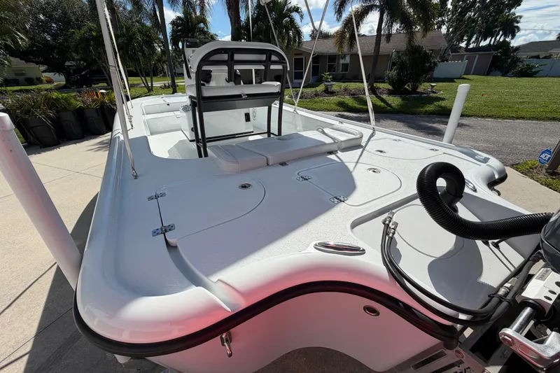 Slide: The Image of 2018 Yellowfin 21 Bay boat with sleek design, parked outdoors under palm trees. - 15