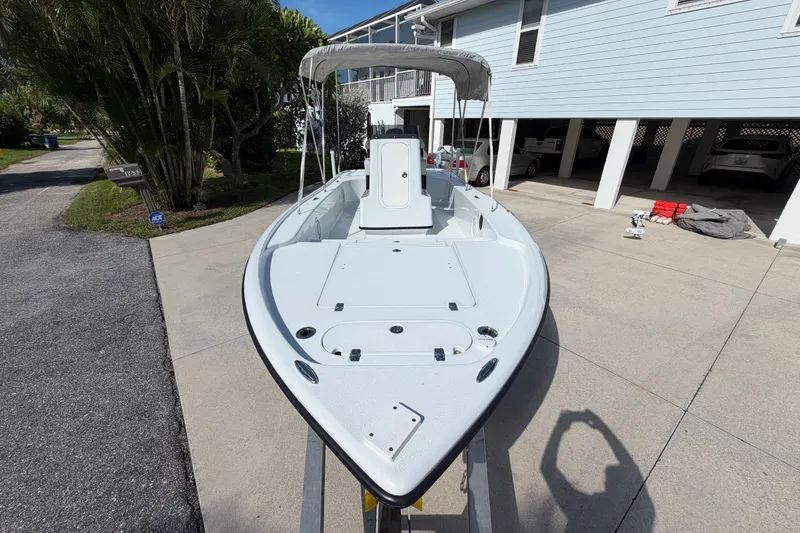 Slide: The Image of 2018 Yellowfin 21 Bay boat parked in a driveway, featuring a sleek design and canopy. - 35