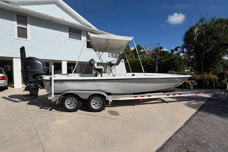 Slide: The Image of 2018 Yellowfin 21 Bay boat on trailer, parked in driveway under clear sky. - 7