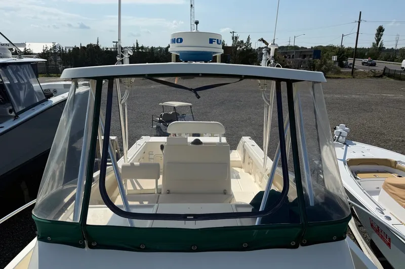 Slide: The Image of 2000 Pursuit 2870 Offshore Center Console boat with clear enclosure, docked outdoors. - 6