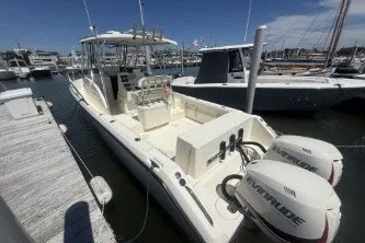 Slide: The Image of 2000 Pursuit 2870 Offshore Center Console boat docked with twin Evinrude engines. - 1
