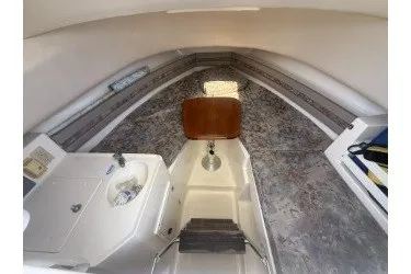 Slide: The Image of 2000 Pursuit 2870 Offshore Center Console cabin interior with sink and seating. - 5