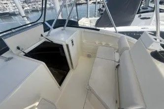 Slide: The Image of 2000 Pursuit 2870 Offshore Center Console boat interior with seating and storage. - 14