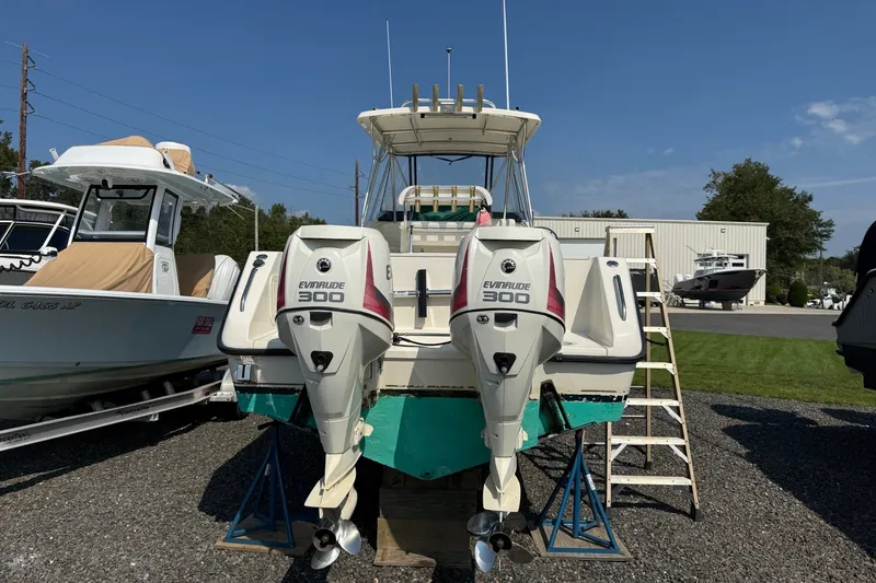 Slide: The Image of 2000 Pursuit 2870 Offshore Center Console with twin Evinrude 300 engines, docked outdoors. - 3