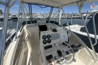 Slide: The Image of 2000 Pursuit 2870 Offshore Center Console boat at marina, featuring helm and controls. - 4