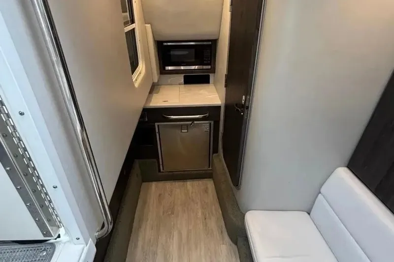 Slide: The Image of Interior of 2022 Formula 350 Crossover Bowrider with kitchenette and seating area. - 16