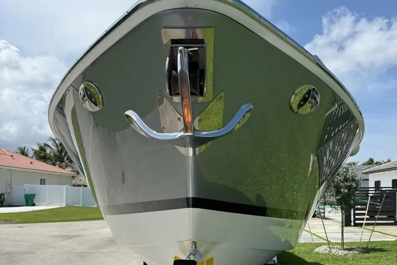 Slide: The Image of 2022 Formula 350 Crossover Bowrider boat, front view, anchored on land. - 2