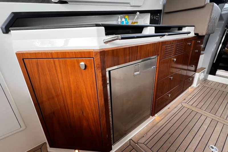 Slide: The Image of 2024 Aquador 300 HT yacht interior with sleek wooden cabinetry and modern amenities. - 29