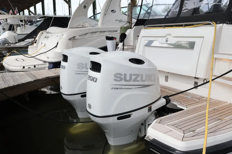 Slide: The Image of 2024 Aquador 300 HT with dual Suzuki outboard engines docked at marina. - 62