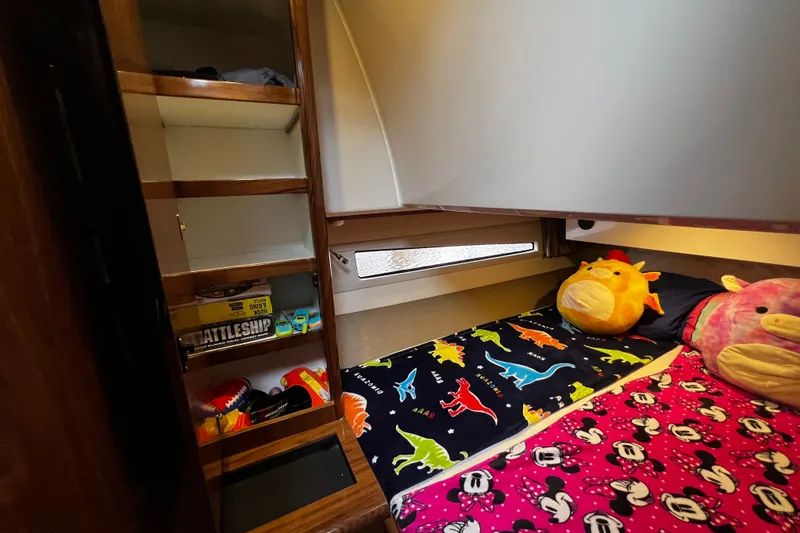Slide: The Image of Cozy cabin interior of 2024 Aquador 300 HT with colorful bedding and plush toys. - 49