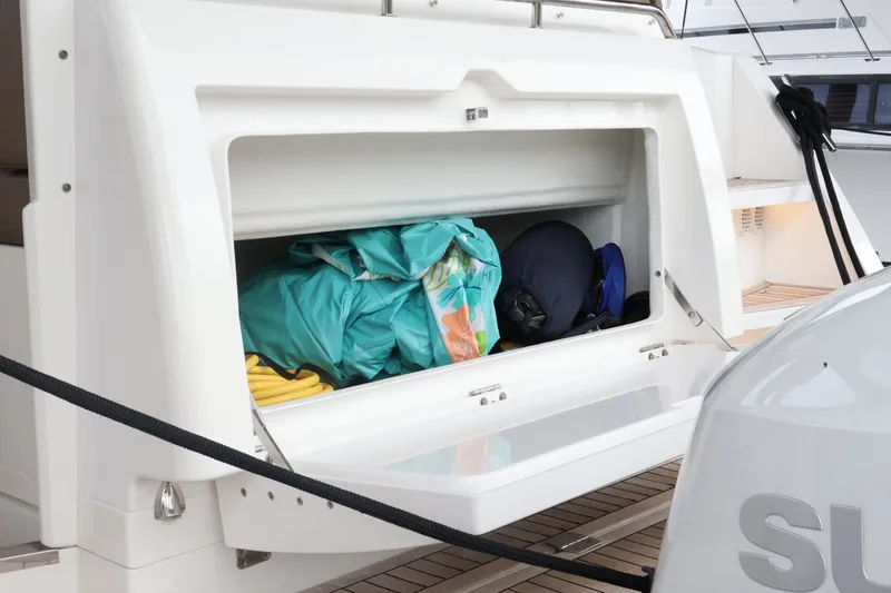 Slide: The Image of Storage compartment on 2024 Aquador 300 HT boat, filled with colorful gear. - 61
