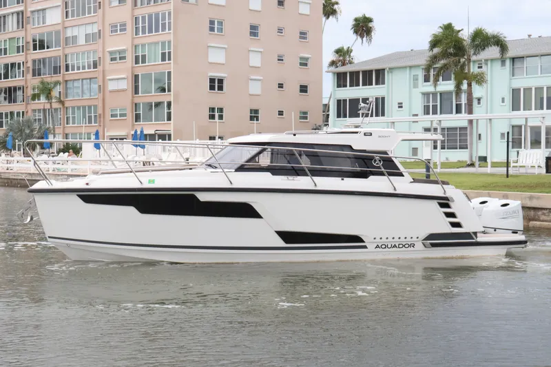 Slide: The Image of 2024 Aquador 300 HT boat docked near waterfront buildings. - 11