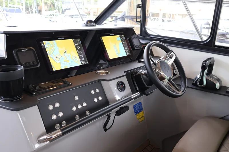 Slide: The Image of Cockpit of 2024 Aquador 300 HT boat with modern navigation displays and controls. - 22