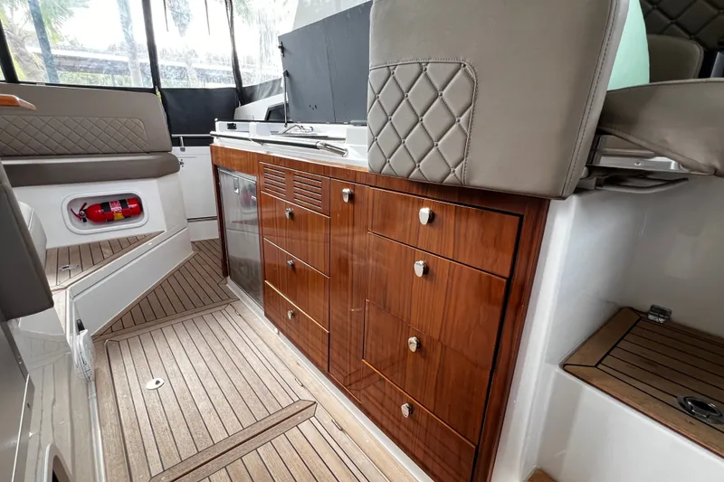 Slide: The Image of 2024 Aquador 300 HT interior with elegant wood cabinetry and modern seating. - 28