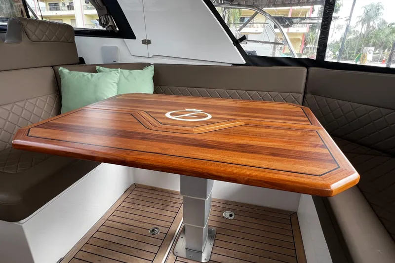 Slide: The Image of Luxurious interior of 2024 Aquador 300 HT yacht with elegant wooden table and cushioned seating. - 41