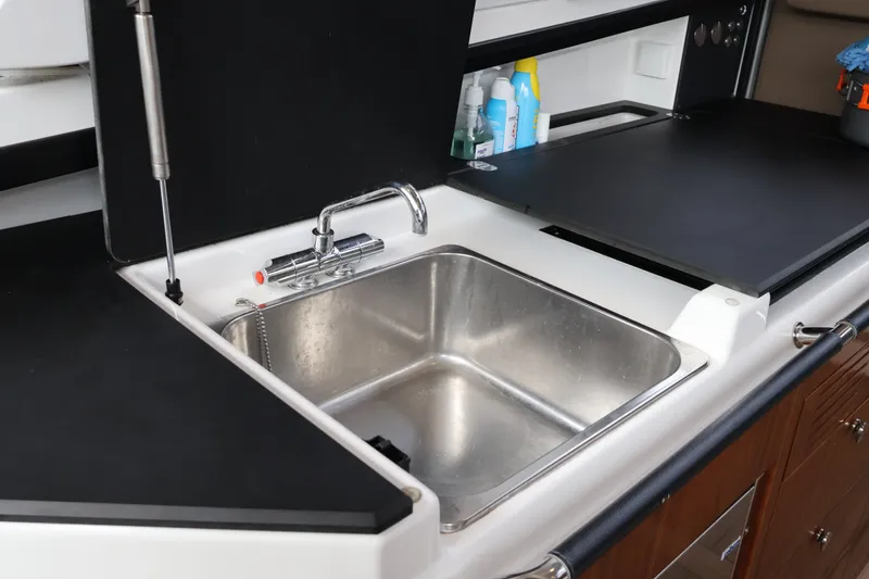 Slide: The Image of 2024 Aquador 300 HT boat kitchen sink with modern faucet and storage space. - 33