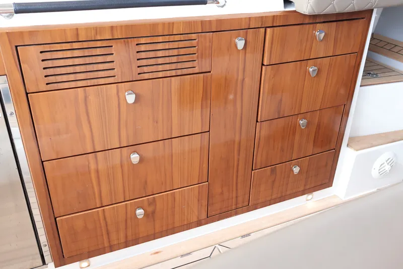 Slide: The Image of Wooden cabinetry on 2024 Aquador 300 HT boat, featuring sleek design and modern handles. - 35