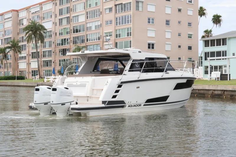 Slide: The Image of 2024 Aquador 300 HT boat docked near waterfront buildings. - 7