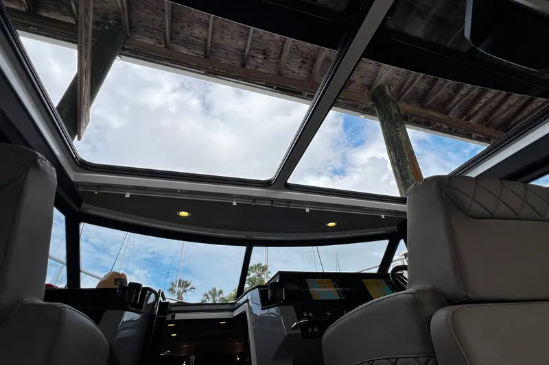 Slide: The Image of Interior view of 2024 Aquador 300 HT boat with glass roof and modern dashboard. - 17