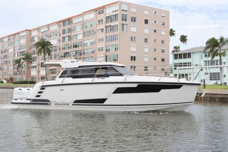 Slide: The Image of 2024 Aquador 300 HT yacht cruising near waterfront buildings. - 5