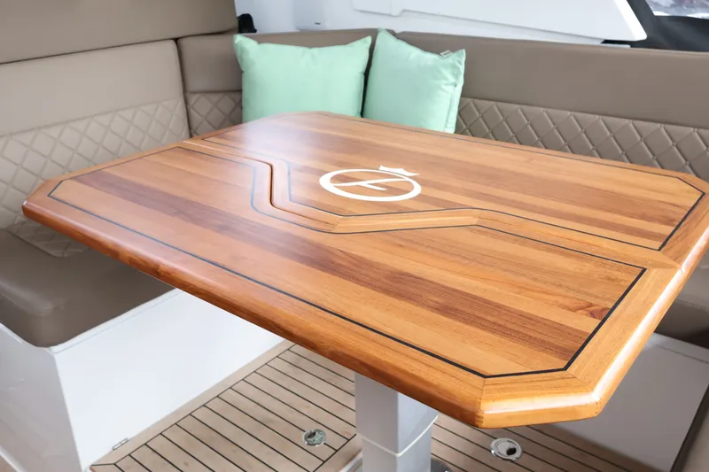 Slide: The Image of Luxurious interior of 2024 Aquador 300 HT with elegant wooden table and cushioned seating. - 39