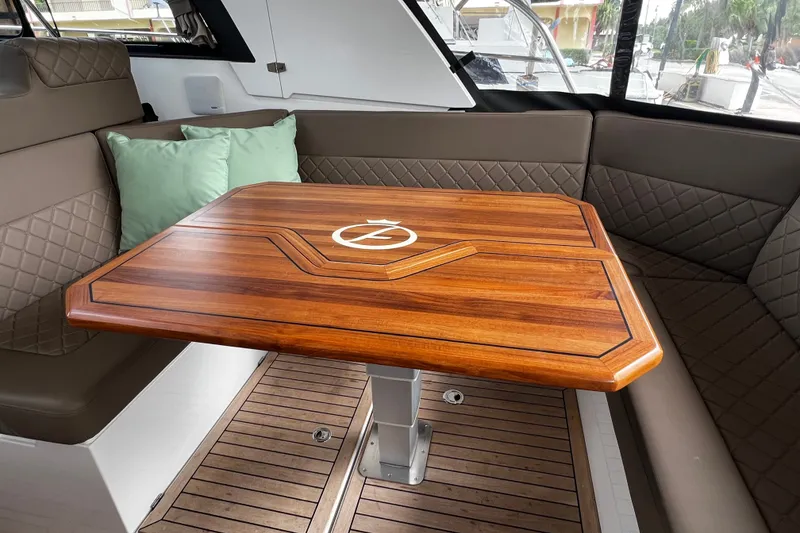 Slide: The Image of Luxurious interior of 2024 Aquador 300 HT yacht with elegant wooden table and cushioned seating. - 42