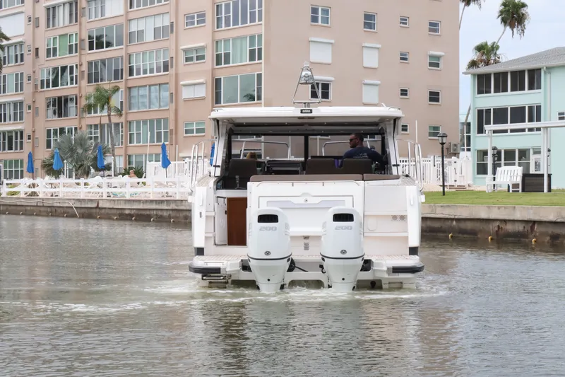 Slide: The Image of 2024 Aquador 300 HT boat cruising near waterfront buildings. - 14