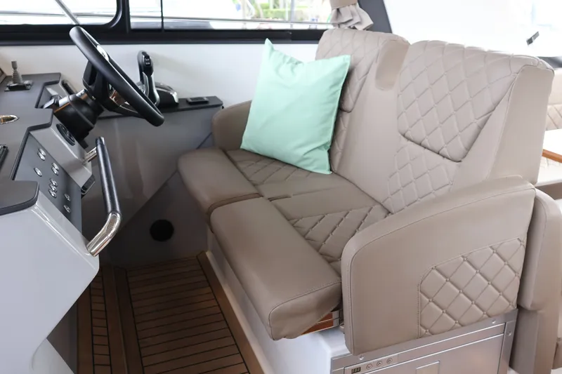 Slide: The Image of Luxurious interior of 2024 Aquador 300 HT boat with quilted seating and steering wheel. - 23