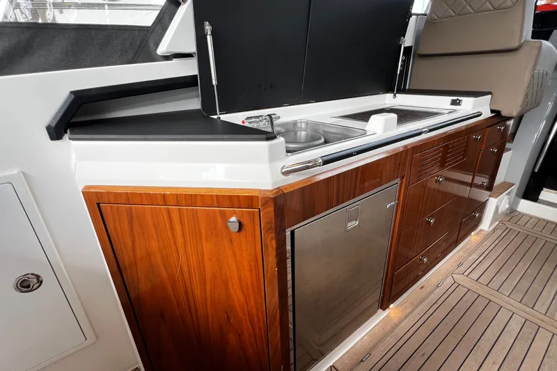 Slide: The Image of Luxurious 2024 Aquador 300 HT yacht kitchen with sleek wood cabinetry and modern appliances. - 30