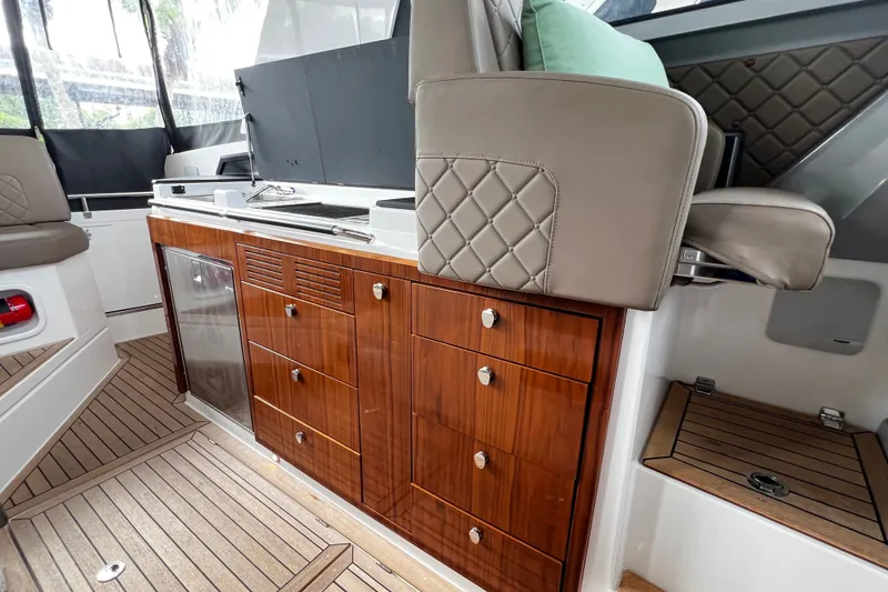 Slide: The Image of 2024 Aquador 300 HT interior with elegant wood cabinetry and modern seating. - 27