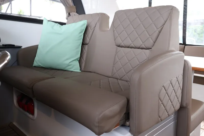 Slide: The Image of Luxurious leather seating with a cushion in the 2024 Aquador 300 HT boat interior. - 24