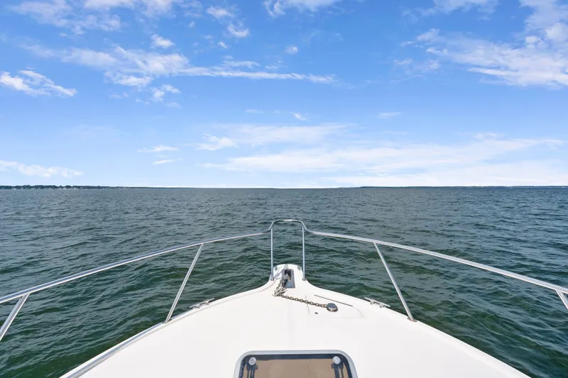 Slide: The Image of Bow view of 1995 Pursuit 3000 Offshore boat on open water under blue sky. - 42