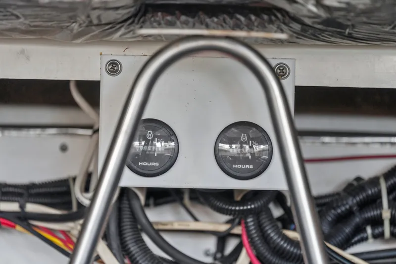 Slide: The Image of Hour meters on a 1995 Pursuit 3000 Offshore boat, surrounded by wiring and metal frame. - 66