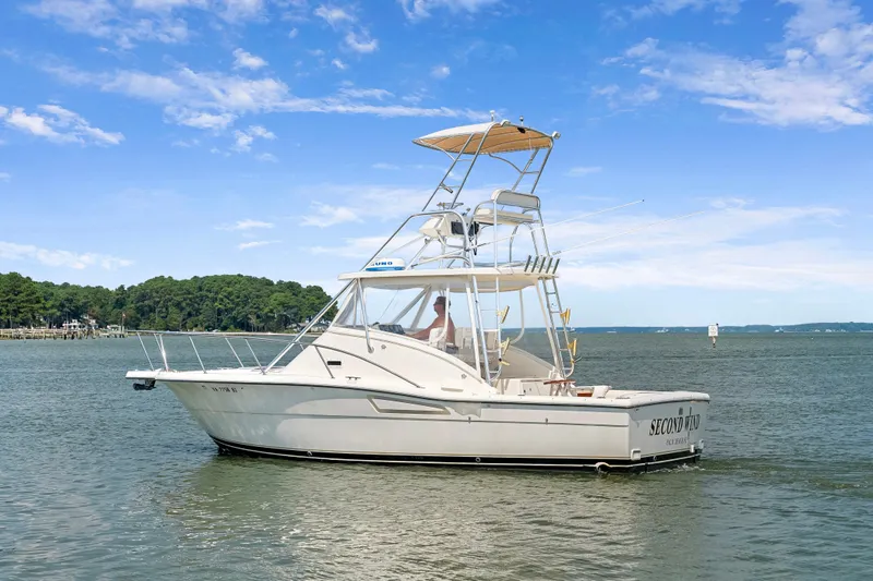 Slide: The Image of 1995 Pursuit 3000 Offshore boat on calm water under a clear blue sky. - 57