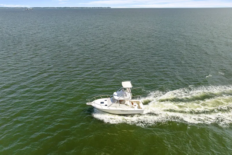 Slide: The Image of Aerial view of 1995 Pursuit 3000 Offshore boat cruising on open water. - 60